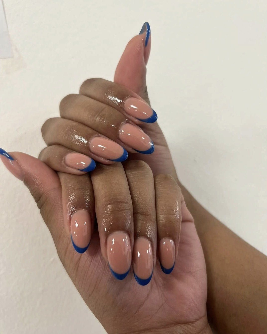 Amandelvormige nagels, nude met een kobaltblauwe French-rand