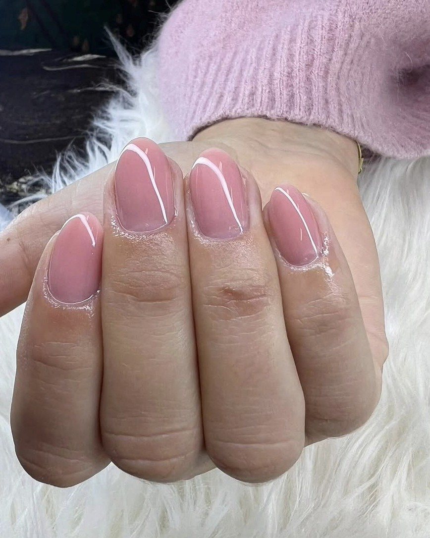 Korte, ronde nagels in zacht roze op een witte vacht